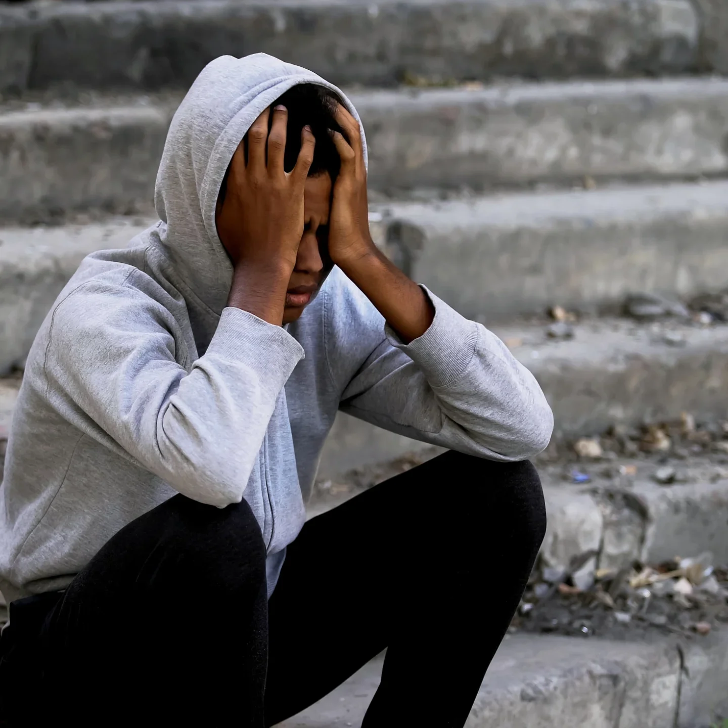 A young person sitting on concrete steps